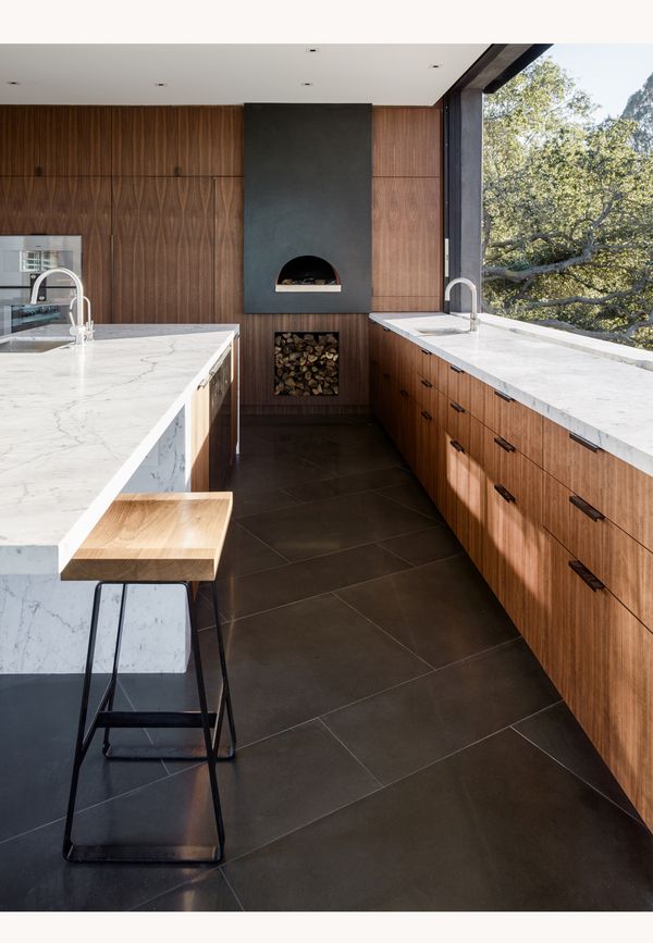Wood and marble kitchen containing Gaggenau 400 series ovens 