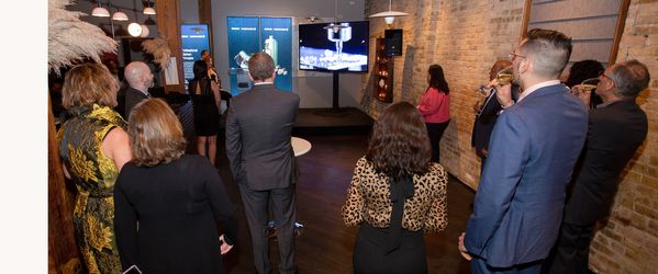 Guests sipping champagne and watching a Gaggenau video presentation. 
