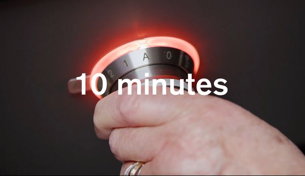 An image showing a hand controlling a Gaggenau cooktop knob
