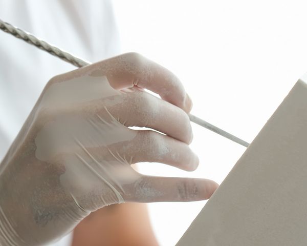 Close-up of person working on the plaster clock housing 