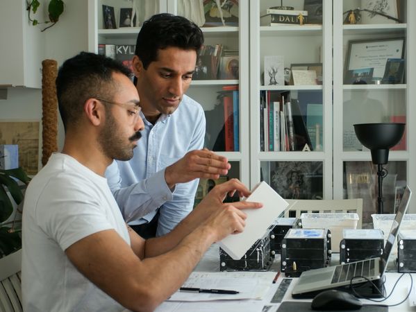 Portrait of Raphaé Memon and Sikander Pervez working the clock concept in an office