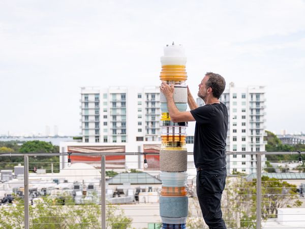Artist Matt Gagnon constructs one of his signature Light Stacks against the Miami skyline.