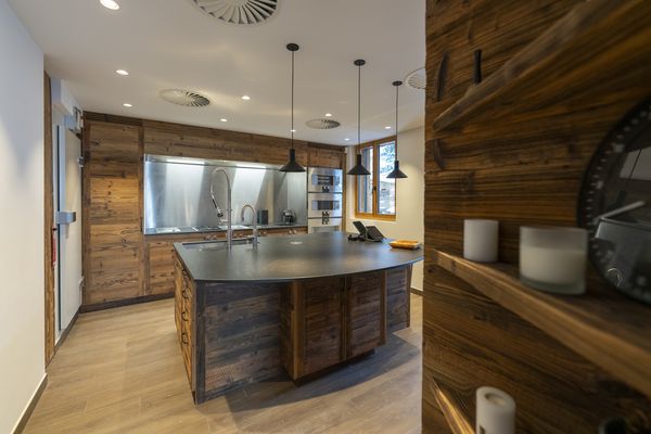 Vista della cucina completa con elettrodomestici Gaggenau e frontali in legno