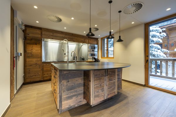 Vista della cucina completa con elettrodomestici Gaggenau e frontali in legno