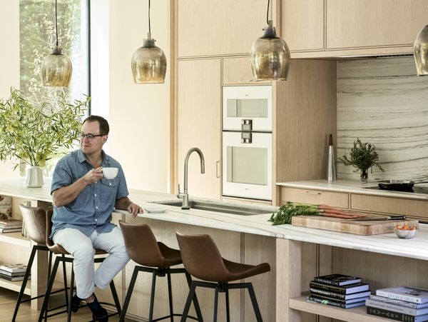 Sam Fertik enjoys a coffee at his kitchen island.
