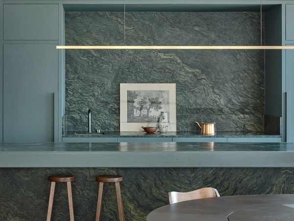Kitchen area in apartment featuring natural timber, refined marble, and bespoke joinery.