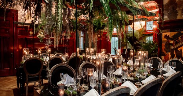 The ornate table setting in the Pillsbury Castle's Grand Salon, with draping greenery above creating a sultry Black Forest ambiance.