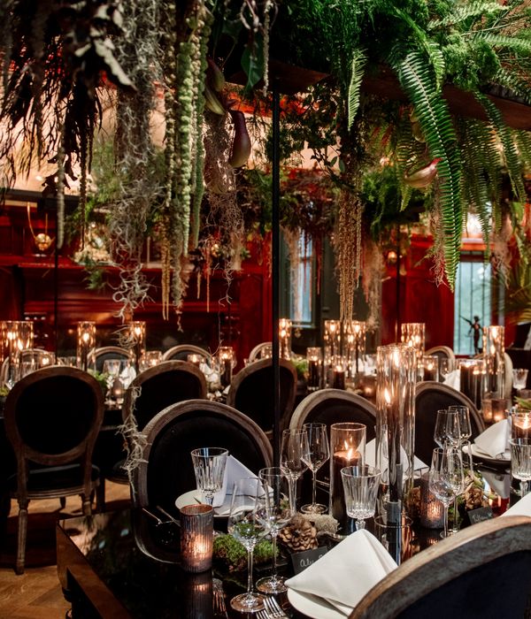 The ornate table setting in the Pillsbury Castle's Grand Salon, with draping greenery above creating a sultry Black Forest ambiance.
