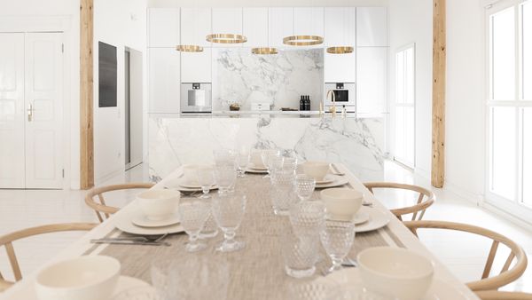 Bright white kitchen with Gaggenau appliances and marble surfaces 