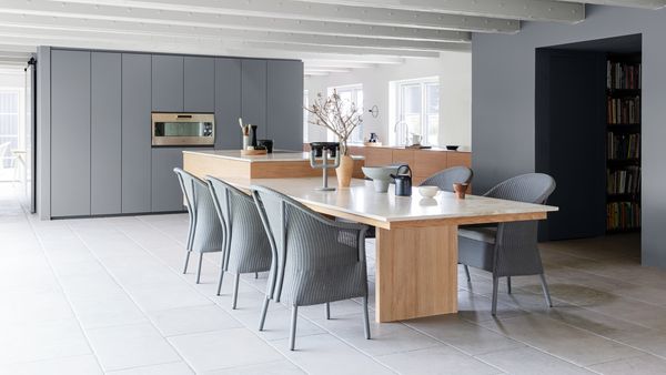 Large luxury kitchen with light gray walls and modern Gaggenau appliances  
