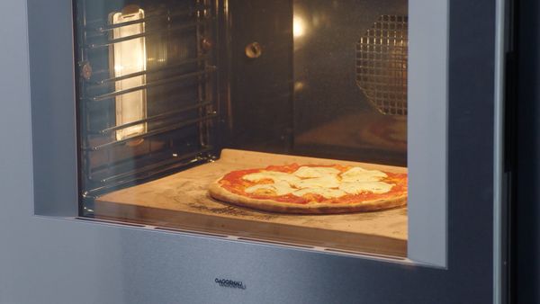 Gaggenau 400 series oven cooking a pizza on a baking stone 