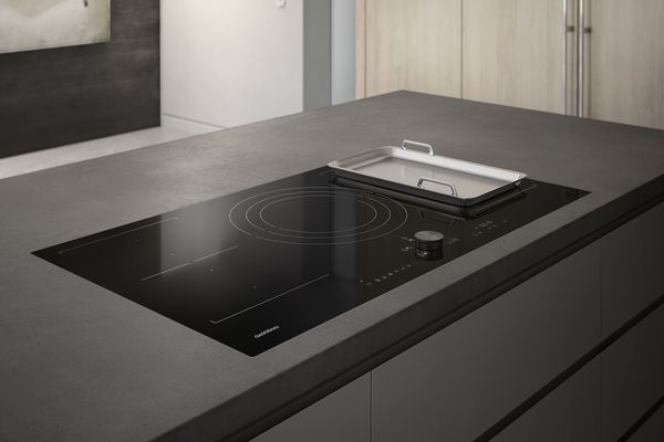 Gaggenau 200 series flex induction cooktop with built-in downdraft ventilation in a modern kitchen