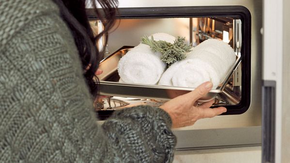 Windsor Smith placing hand towels in her Gaggenau Combi-steam oven