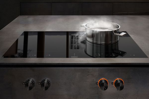 Modern bir mutfakta tezgah havalandırmalı Gaggenau 400 serisi flex indüksiyonlu ocak