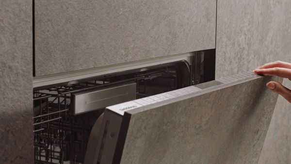 An owner opening an integrated Gaggenau 400 series dishwasher  