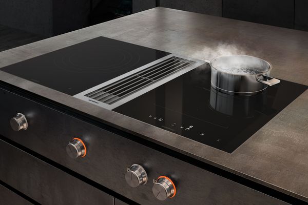 Gaggenau 400 series flex induction cooktop with built in downdraft ventilation in a modern kitchen