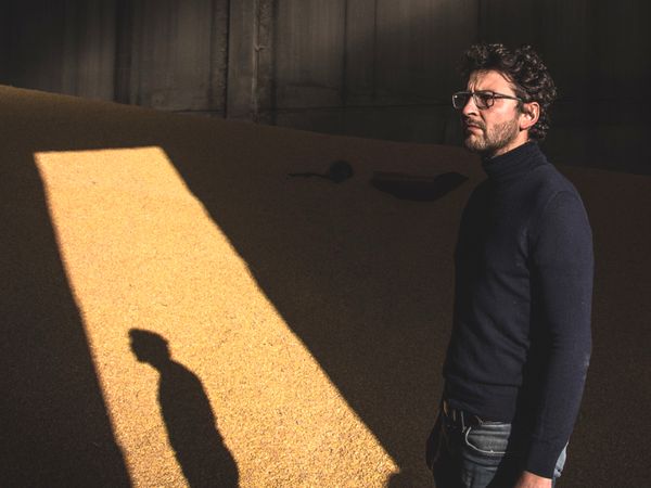 Immagine di Stefano Bettella di Salumi Bettella in piedi in uno stabilimento di conservazione di cereali