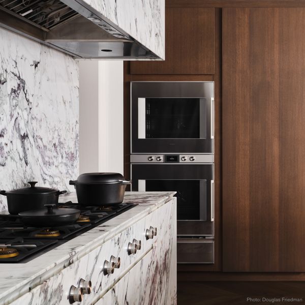 Brightly lit luxury marble kitchen with Gaggenau appliances 