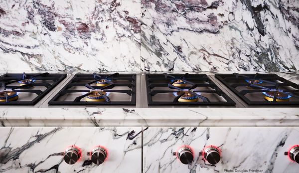 A row of Gaggenau Vario dual gas hobs in marble kitchen worktop 
