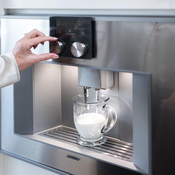 Une personne qui prépare un café avec une machine à espresso entièrement automatique de Gaggenau 