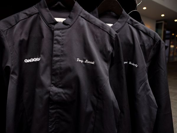 Black jackets hanging on a rack. 