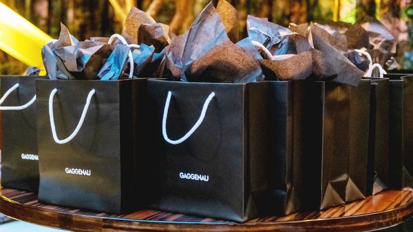 Rows of black Gaggenau-branded gift bags sitting on a table. 