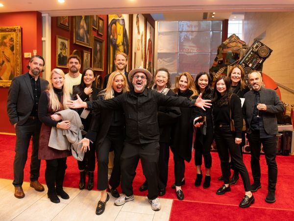 Mr. Brainwash poses enthusiastically with Club 1683 members at his museum. 