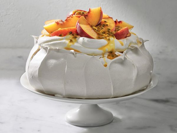 Peaches and cream pavlova on a cake stand