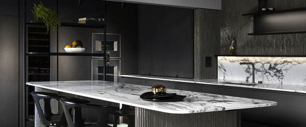 Gaggenau appliances installed in a luxury dark kitchen with island worktop