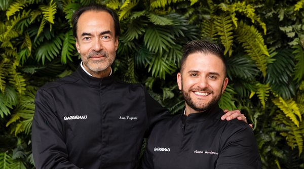 Chef Verzeroli and Chef Barrientos smiling and posing together in their Black Jackets outside of the restaurant. 