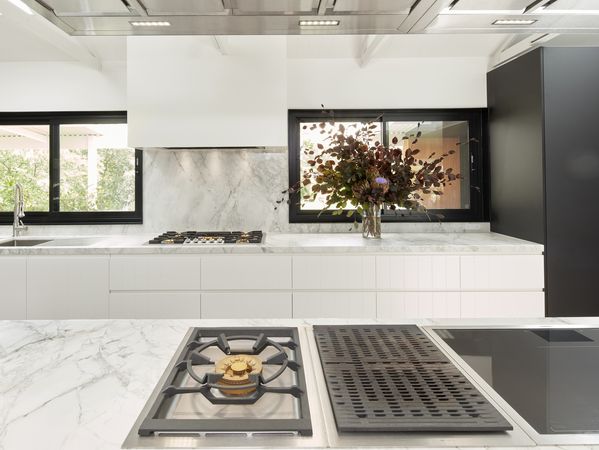Gaggenau appliances installed in a bright luxury kitchen with island worktop, designed with Tony Tan