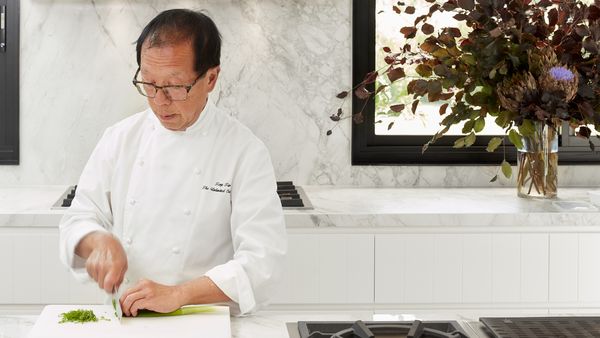 Tony Tan preparing food in a bright luxury kitchen he designed