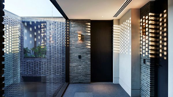 Elwood house’s Danish light-well brickwork casting shadows on the walls