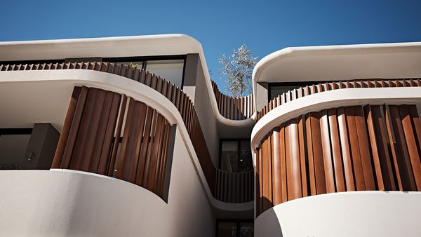 External view of the curvilinear architecture and wooden louvres that make up the facade and balconies