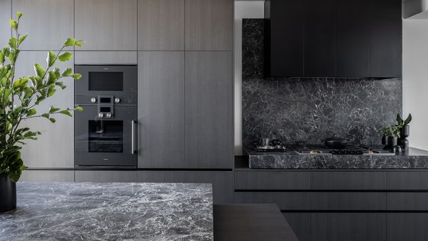 Gaggenau appliances installed in a light grey and wood luxury kitchen with matching stone benchtops 