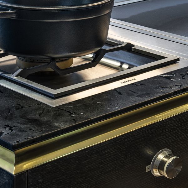 Close-up of Gaggenau appliances installed in a dark luxury kitchen island worktop