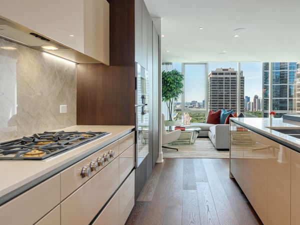 A kitchen and living space in The Residences at The St. Regis Chicago featuring Gaggenau appliances.