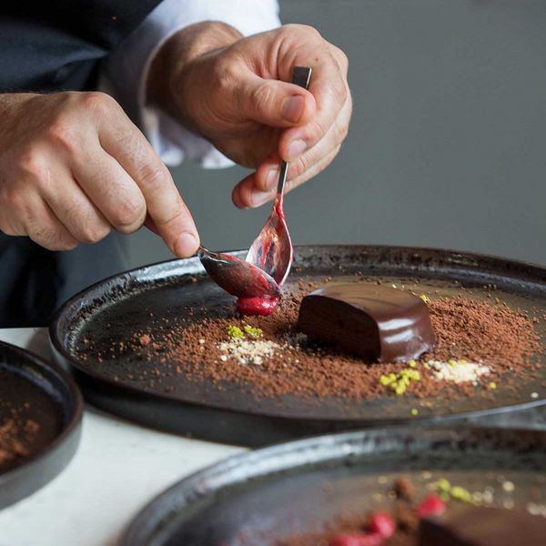 Close-up of chef Romuald Oudeyer putting the finishing touches to a dessert
