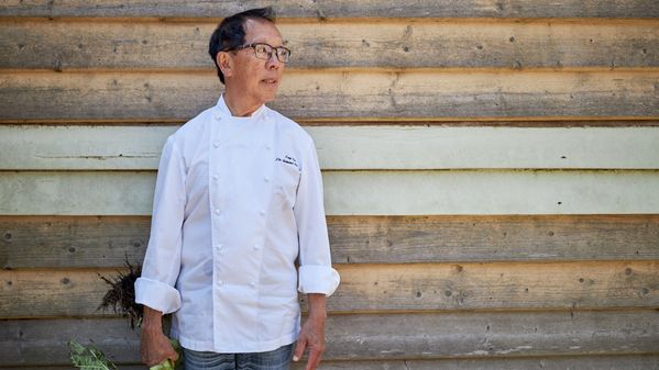 Portrait of chef Tony Tan against a wooden fence