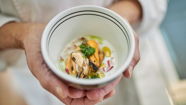 Close up of chef Tony Tan’s hands holding a bowl of seafood