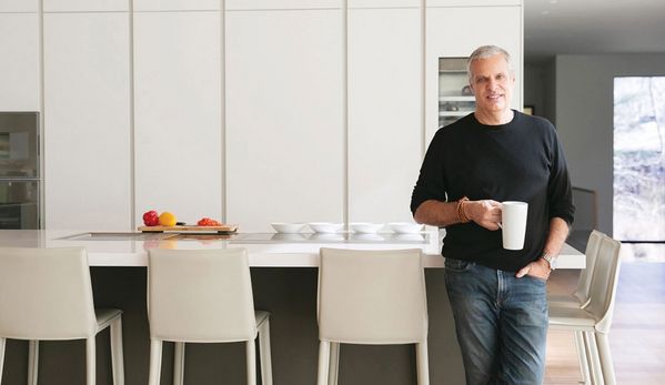 Chef Eric Ripert smiling in his home kitchen, where Gaggenau appliances can be seen. 