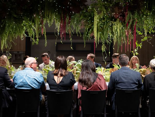 Guests sat at a table ornately decorated with live ferns, moss, and twinkling lights. 