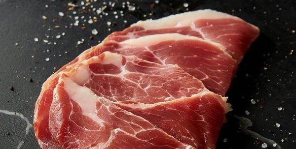 Close-up of seasoned ham on a marble worktop