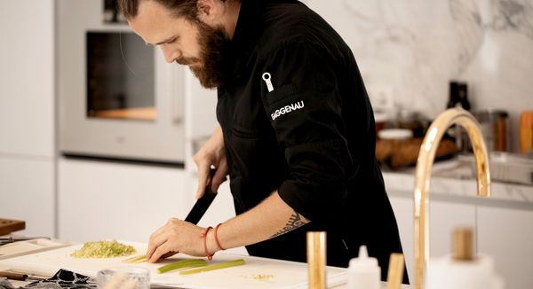 A Gaggenau chef prepares a meal in a bright luxury kitchen