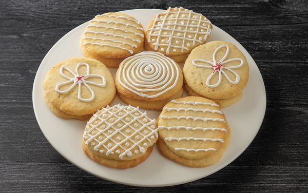 Close-up image of a plate containing sugar cookies decorated with royal icing