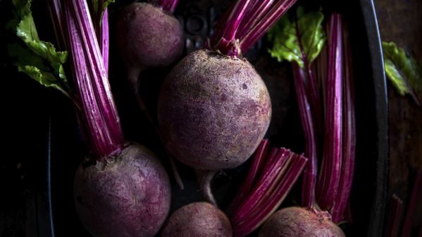 Close-up of raw red beets in a dark dish