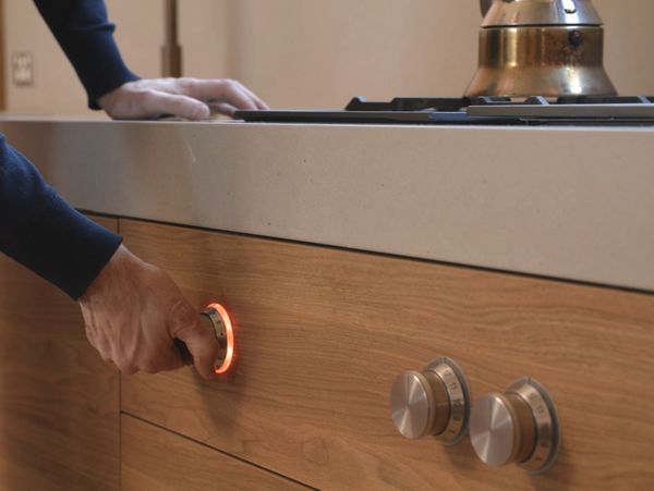 Close-up of Andrew Piva’s hand using the Gaggenau control knob in his kitchen