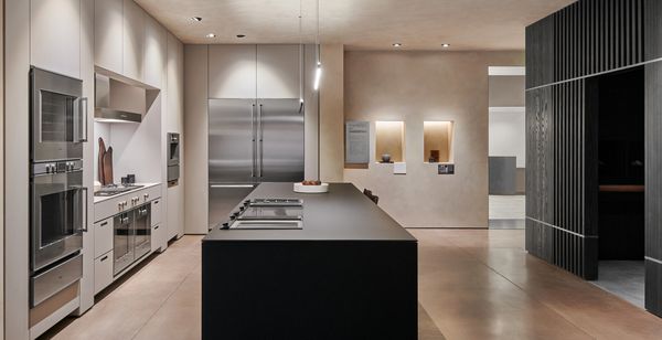 The showroom's secondary kitchen, decorated in rich blacks lit by dazzling Occhio lights. 