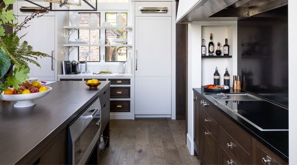 Another angle of Tolles' lakehouse kitchen, with a view of her Gaggenau induction cooktop as well as the large refrigerator which blends seamlessly into the rest of the white cabinetry. 