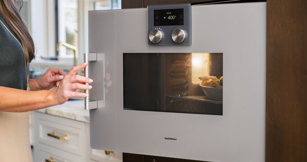 A close-up of Lauren Tolles opening her Gaggenau combi-microwave. 